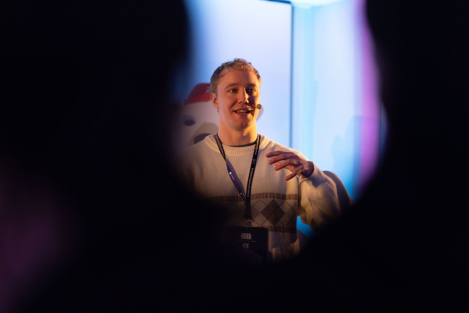 Ronny Eriksson seen through a gap in the crowd, the room turned towards him