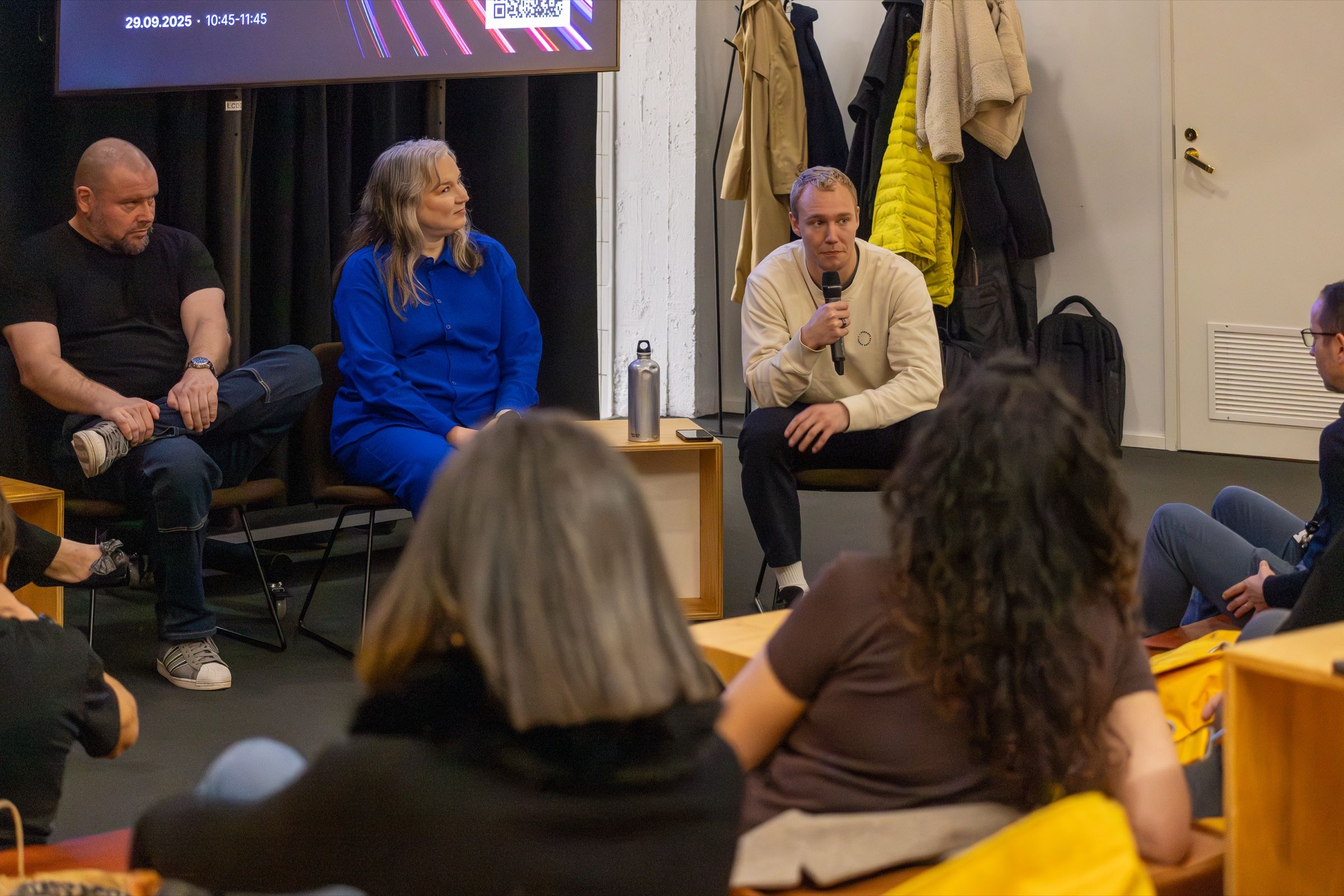 Ronny Eriksson with a microphone on a panel, an audience on beanbags