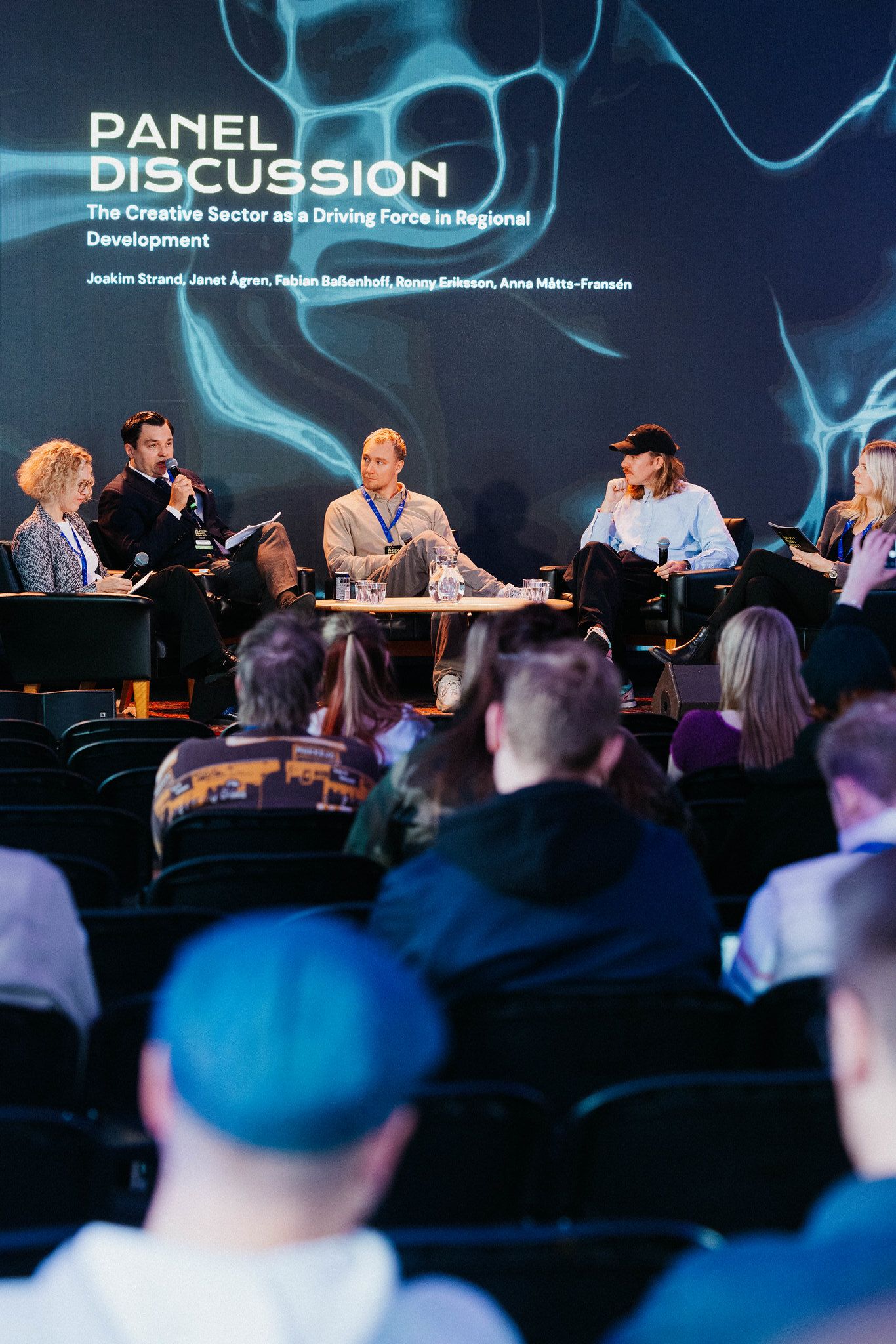 A panel of five in armchairs under a screen reading The Creative Sector as a Driving Force in Regional Development, Ronny Eriksson in the middle, an audience in front
